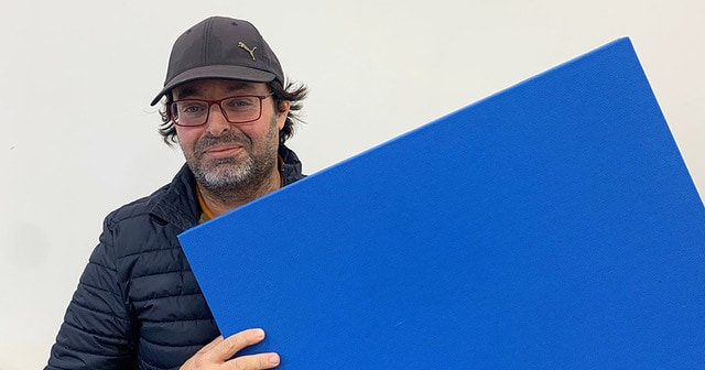 L’entrepreneur Anis Ben Aicha tenant un panneau acoustique bleu