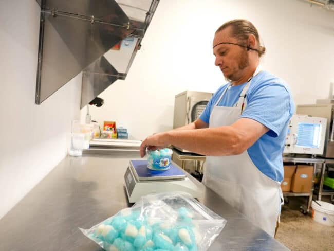 Un associé des bonbons Crunch Pop procède à l'emballage des bonbons destinés à la vente. 